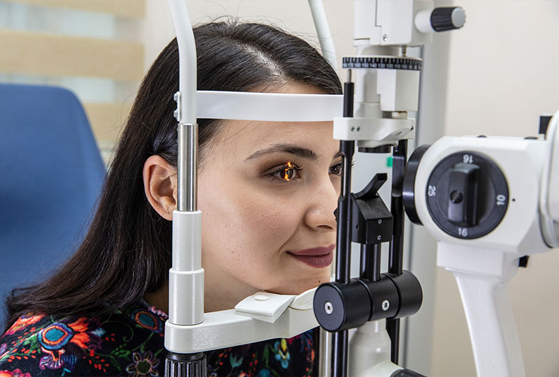 A photograph of three individuals, a man and two women, in a professional setting, seated on a couch with one woman holding an envelope while the others look at her.